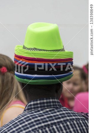 hat seller with various hats on his head 138398649
