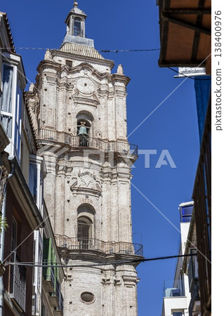 Majestic bell tower rising above narrow streets in Malaga, Spain, under a brilliant blue sky during midday Majestic bell tower rising above narrow streets in Malaga, Spain, under a brilliant blue sky during midday 138400976