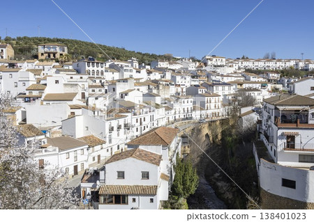 View of Setenil de las Bodegas with white houses and river in sunny weather View of Setenil de las Bodegas with white houses and river in sunny weather 138401023