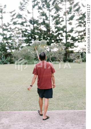Solo traveler walking toward open green countryside Solo traveler walking toward open green countryside 138401117