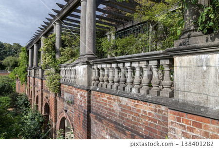 The Hill Garden and Pergola is an Edwardian-era structure overlooking Hampstead Heath. It consists of a timber-trellis walkway elevated by stone Doric columns and a red-brick arched foundation. A 138401282
