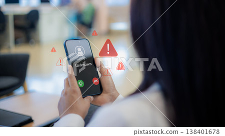 Call center scam and fraud warning.Unknown caller id with warning icon.Mobile phone phishing and cyber crime.Digital fraud protection and safety concept.Woman holding phone with phishing alert. Call center scam and fraud warning.Unknown caller id with warning icon.Mobile phone phishing and cyber crime.Digital fraud protection and safety concept.Woman holding phone with phishing alert. 138401678