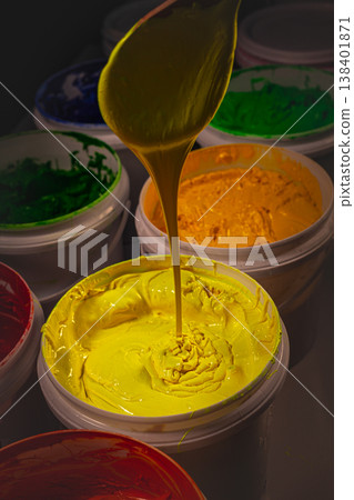 Close up view of yellow paint buckets with wooden spatulas. Close up view of yellow paint buckets with wooden spatulas. 138401871