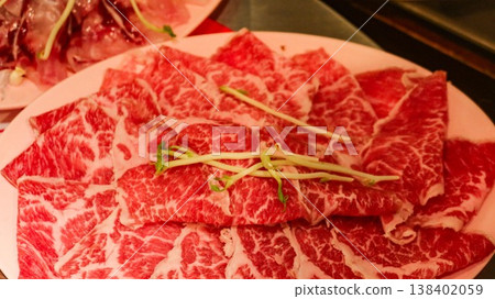 close up of marbled red raw pork meat slice arranged in circular pattern with bean sprout garnish on a plate which is ingredient for hot pot with copy space close up of marbled red raw pork meat slice arranged in circular pattern with bean sprout garnish on a plate which is ingredient for hot pot with copy space 138402059