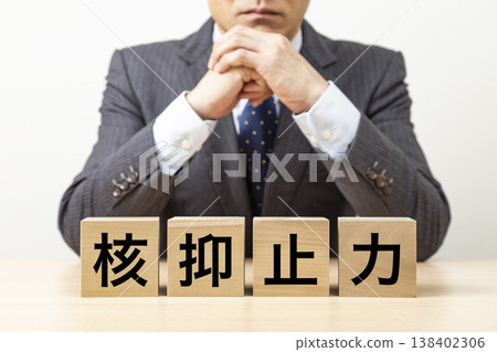 一塊寫著「核子威懾」字樣的磚塊和一個商人 一塊寫著「核子威懾」字樣的磚塊和一個商人 138402306