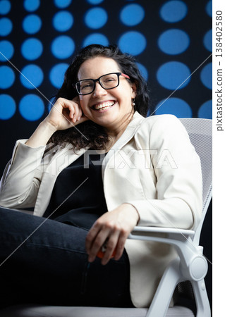 Professional woman wearing glasses smiling in office setting Professional woman wearing glasses smiling in office setting 138402580