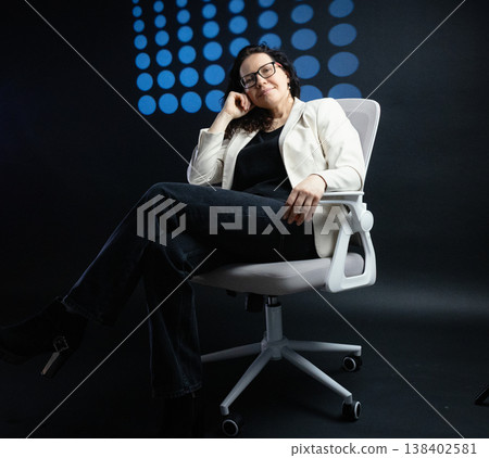 Confident business woman sitting in modern office chair 138402581