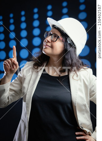 Woman engineer pointing up, looking at innovation Woman engineer pointing up, looking at innovation 138402587