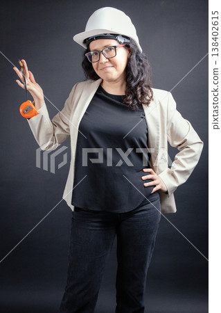 Woman engineer holding measuring tape and pencil Woman engineer holding measuring tape and pencil 138402615