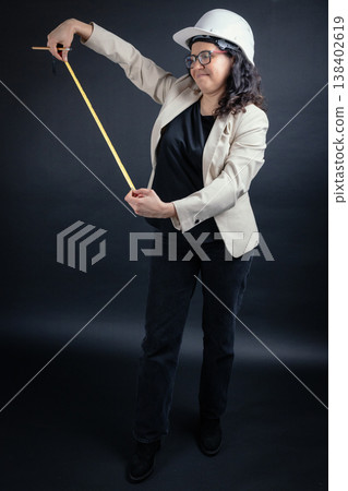 Woman architect or engineer measuring with tape and pencil 138402619