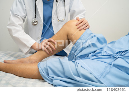 Doctor checking Asian elderly woman patient with scar knee replacement surgery in hospital. 138402661