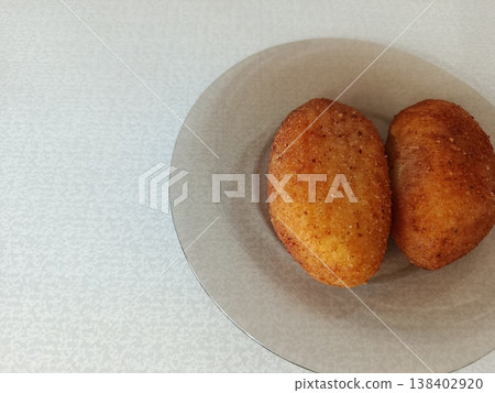 Golden fried delicious pirozhki or homemade savory buns on a transparent plate, fresh warm snack, traditional cuisine, comfort food eating 138402920