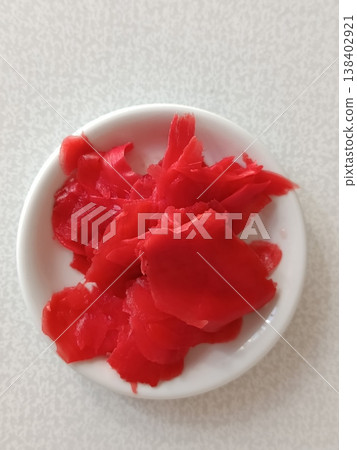 Pickled red ginger gari in a small white dish, offering a refreshing palate cleanser for sushi and japanese cuisine, highlighting natural flavors and healthy ingredients 138402921