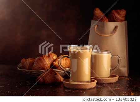 Coffee latte and croissants on a brown table. 138403022
