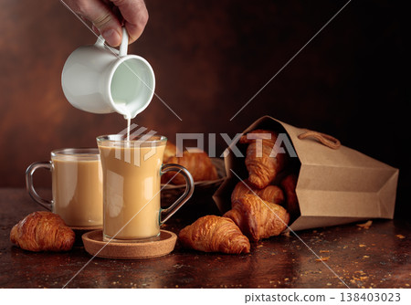 Coffee latte and croissants on a brown background. Coffee latte and croissants on a brown background. 138403023