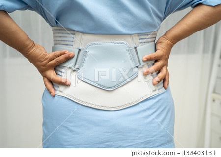 Asian senior pain back wearing elastic support belt with walker. Asian senior pain back wearing elastic support belt with walker. 138403131