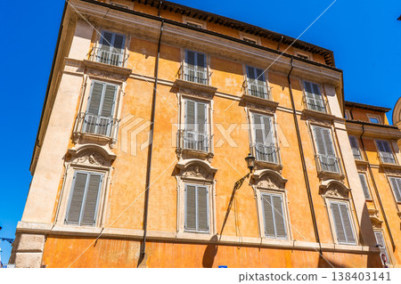 Italy Rome street bright house facade. Old historical building architecture in the city center. Italian windows with shutters. Italy Rome street bright house facade. Old historical building architecture in the city center. Italian windows with shutters. 138403141