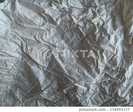 Worn grunge paper surface with intense halftone scatter. A crushed blank sheet, jagged creases. 138403157