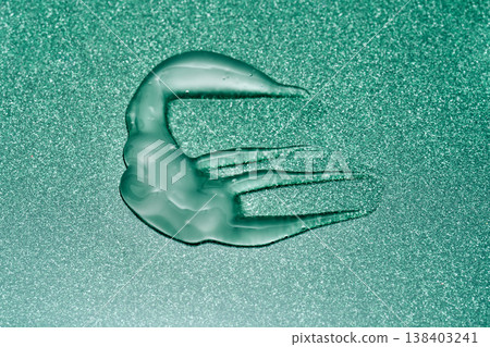 Green cosmetic gel texture spreading on glitter background Green cosmetic gel texture spreading on glitter background 138403241