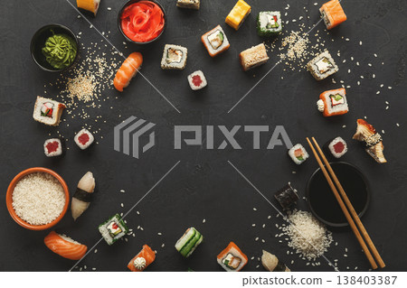 Sushi and rolls background, frame on black, top view. Colorful japanese restaurant food set, copy space 138403387