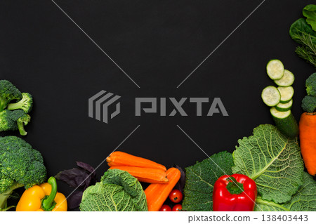 Fresh vegetables border on black background. Vegetarian cooking. Healthy natural food with copy space. Fresh vegetables border on black background. Vegetarian cooking. Healthy natural food with copy space. 138403443