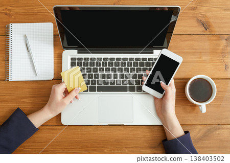 Woman using laptop. Freelancer working with portable computer in coffee shop, top view, close up Woman using laptop. Freelancer working with portable computer in coffee shop, top view, close up 138403502