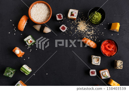 Sushi and rolls background, frame on black, top view. Colorful japanese restaurant food set Sushi and rolls background, frame on black, top view. Colorful japanese restaurant food set 138403539