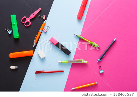 Stationery supplies and devices on pop art background. Top view, flat lay, mockup of creative work space at modern office with markers, rubbers, pens, scissors and binder clips Stationery supplies and devices on pop art background. Top view, flat lay, mockup of creative work space at modern office with markers, rubbers, pens, scissors and binder clips 138403557