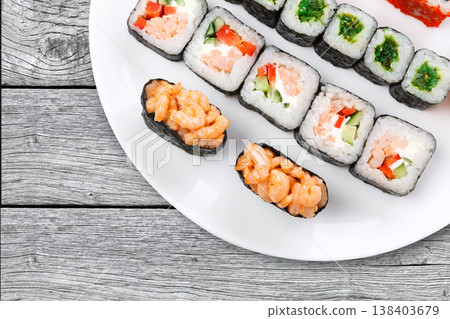 Japanese restaurant background, rolls and sushi platter closeup. Set crop, top view on rustic gray wood Japanese restaurant background, rolls and sushi platter closeup. Set crop, top view on rustic gray wood 138403679