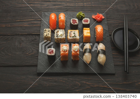 Japanese food restaurant, sushi and rolls on dark background. Set with chopsticks and soy sauce. Copy space on black wood Japanese food restaurant, sushi and rolls on dark background. Set with chopsticks and soy sauce. Copy space on black wood 138403740