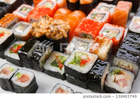 Japanese food restaurant delivery. Sushi and rolls pattern background. Salmon, unagi, california and other colorful healthy meals Japanese food restaurant delivery. Sushi and rolls pattern background. Salmon, unagi, california and other colorful healthy meals 138403749
