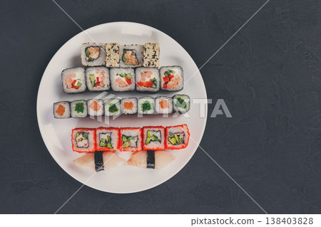 Japanese food restaurant, california salmon rolls and sushi platter. Top view on black background Japanese food restaurant, california salmon rolls and sushi platter. Top view on black background 138403828