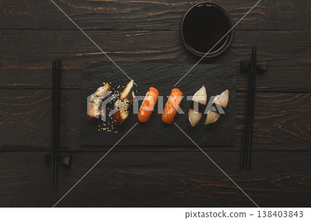 Colorful sushi platter in japanese restaurant, with chopsticks and soy sauce on dark wooden background, top view, flat lay, copy space Colorful sushi platter in japanese restaurant, with chopsticks and soy sauce on dark wooden background, top view, flat lay, copy space 138403843