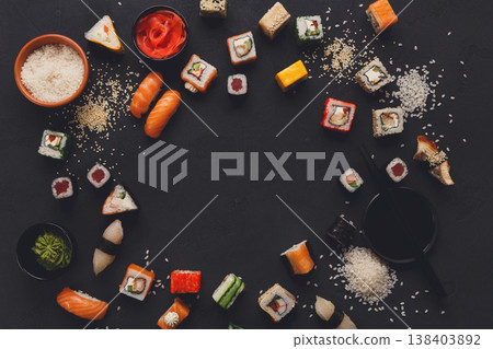 Sushi and rolls background, border on black, top view, copy space. Colorful japanese restaurant food set Sushi and rolls background, border on black, top view, copy space. Colorful japanese restaurant food set 138403892