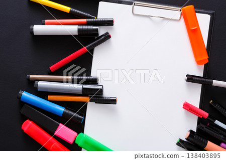 Stationery for drawing - top view of color markers variety and tablet with white blank paper on black desktop background. Desiner workplace with copy space on sketchbook, closeup Stationery for drawing - top view of color markers variety and tablet with white blank paper on black desktop background. Desiner workplace with copy space on sketchbook, closeup 138403895