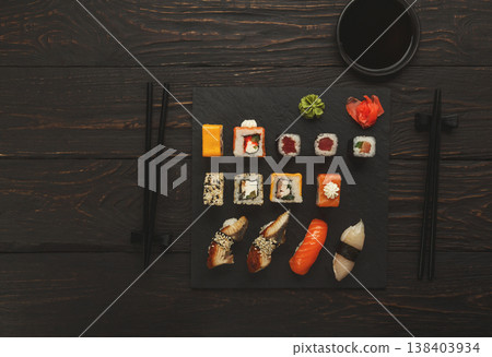 Colorful sushi platter in japanese restaurant, with chopsticks and soy sauce on dark wooden background, top view, flat lay, copy space Colorful sushi platter in japanese restaurant, with chopsticks and soy sauce on dark wooden background, top view, flat lay, copy space 138403934