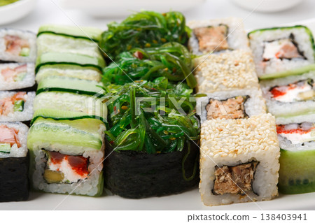 Traditional japanese cuisine background. Sushi set of fish rolls and gunkans with seaweed and sesame closeup 138403941