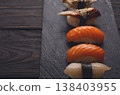 Sushi plate. Japanese food restaurant, eel, salmon and snapper sushi closeup on dark background. Pov with copy space on black wood 138403955