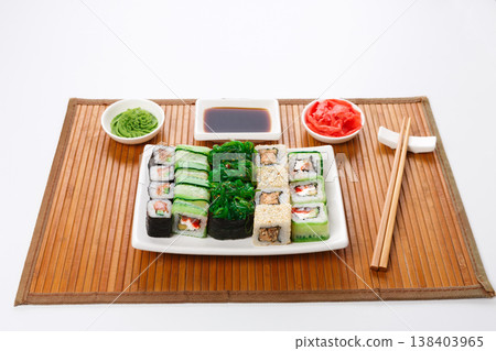 Japanese food restaurant delivery - sushi maki, unagi and roll platter set on mat isolated on white background 138403965