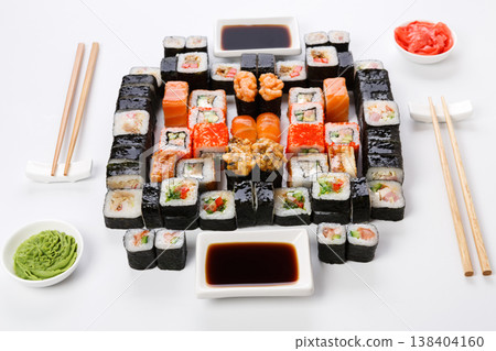 Sushi delivery. Set of rolls, unagi, gunkan served with chopsticks, soy sauce, ginger, wasabi on white background. Japanese dinner for two, pov 138404160
