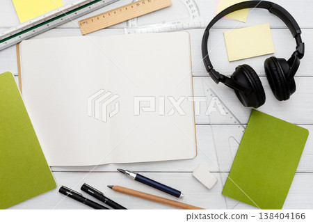 Workspace top view, education concept, modern workplace. Stationery supplies - blank notepad and headphones on white wooden desktop, flat lay, copy space, mockup 138404166