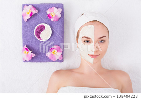 Face mask, spa beauty treatment. Woman applying facial clay mask at spa salon, skincare, top view, overhead Face mask, spa beauty treatment. Woman applying facial clay mask at spa salon, skincare, top view, overhead 138404228