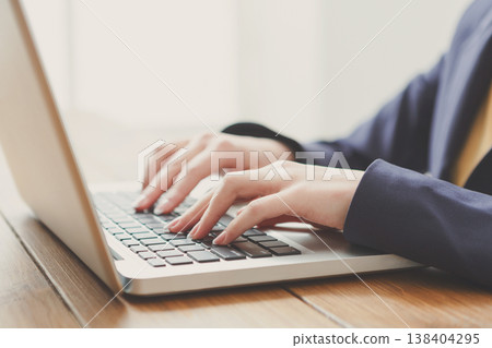 Business woman working in office, typing on laptop, close-up Business woman working in office, typing on laptop, close-up 138404295