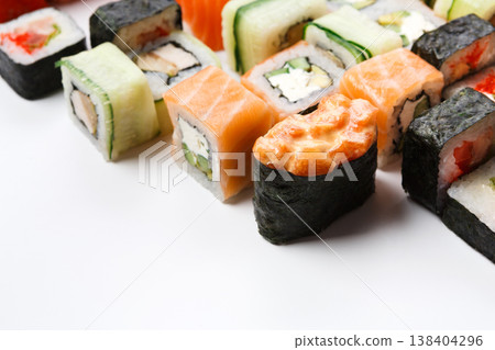 Traditional japanese restaurant food. Colorful rolls and gunkan with salmon closeup at white with copy space. Big party sushi set, pov, sushi assortment background Traditional japanese restaurant food. Colorful rolls and gunkan with salmon closeup at white with copy space. Big party sushi set, pov, sushi assortment background 138404296