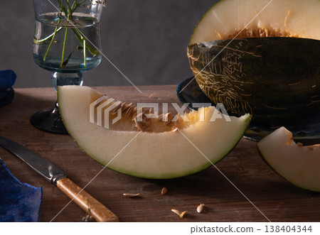 piece of melon on a wooden background and a knife piece of melon on a wooden background and a knife 138404344