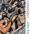 Metal scrap yard contains various rusty auto parts and machinery scattered throughout the area during a sunny day 138404403