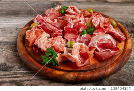 Assortment , sliced meat appetizer, prosciutto, salami and ham, with olives, on a wooden board, breakfast, top view, close-up, no people, Assortment , sliced meat appetizer, prosciutto, salami and ham, with olives, on a wooden board, breakfast, top view, close-up, no people, 138404595