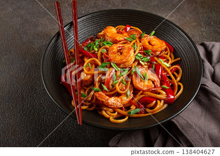 udon stir-fry shrimp noodles with red bell pepper and green onion, served in a black bowl, with chopsticks, dark background, 138404627