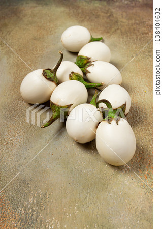 white mini eggplant, scattered on the table, close-up. 138404632