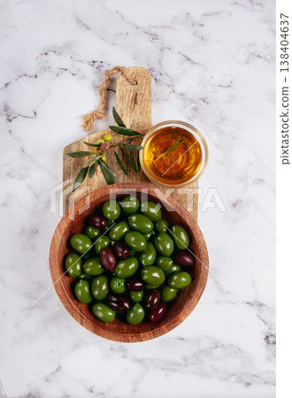 Chalkidiki olives, classic Greek green olives, in a bowl on a cutting board, top view, without people, Chalkidiki olives, classic Greek green olives, in a bowl on a cutting board, top view, without people, 138404637